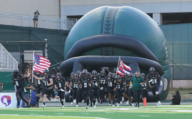UH Manoa Football team runs on the field at Clarence TC Ching Athletic Complex in their first home game held at the stadium. September 4, 2021
