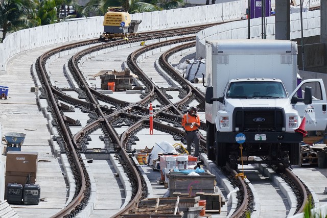 Workers work on train guideway and rails at the Daniel K. Inouye International Airport.