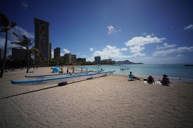 View of Waikiki Beach and Diamond Head with noticeably less visitors lounging on the beach.