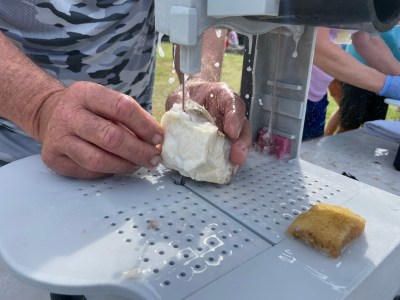 Todd Fisher slowly wiggles a coral fragment against the diamond blade during the Restore With Resilience event Saturday.