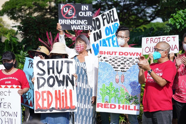 Demonstrators hold signs during a gathering at the Federal Building in opposition to the recent Red Hill US Navy fuel spill.