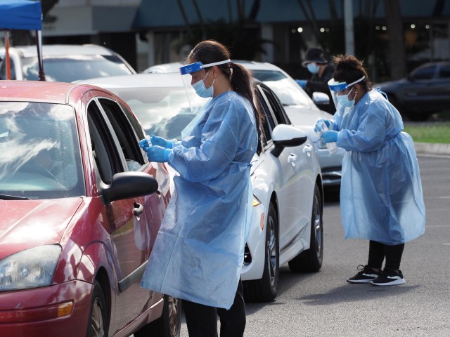 Medical technicians collect COVID-19 nose swab samples from people lined up in their cars, around the block, at the Blaisdell drive-through testing site in Honolulu, Monday, December 27, 2021. (Ronen Zilberman photo Civil Beat)