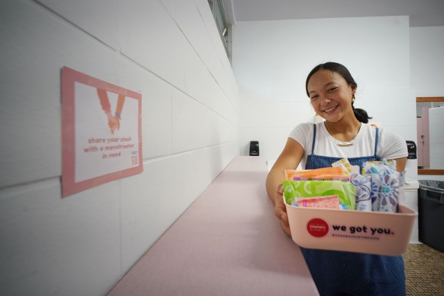 Punahou student Austen Kinney holds a 'we got you' container with feminine products to assist young girls. This container was placed in the girls bathroom at Punahou School.