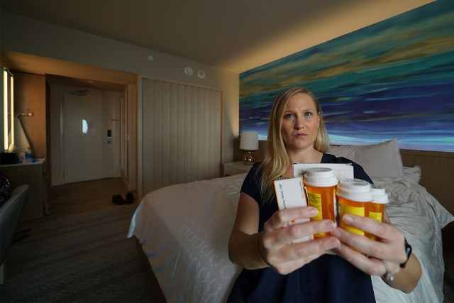 Meredith Wilson holds some of her medications in her room at the Sheraton Waikiki. Wilson has been living at the hotel waiting on guidance from the military on when she can permanently move back to Joint Base Pearl Harbor-Hickam. January 5, 2022.