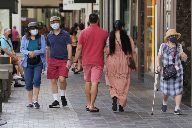 Masked shoppers walk at Ala Moana Shopping center during a decline in Covid-19 cases statewide. Feb. 25. 2022.