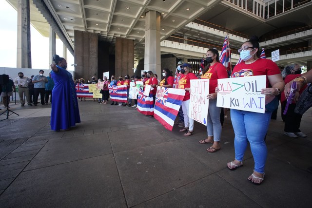 Demonstrators hold signs calling for the closing of the Red Hill fuel tanks at the Capitol Rotunda.