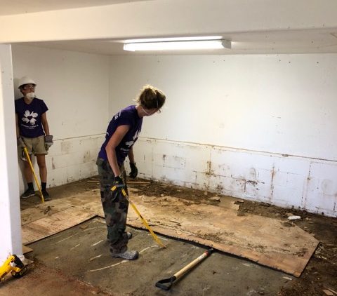 Volunteers help clean up the sewing room after it was destroyed in Hurricane Lane in 2018.