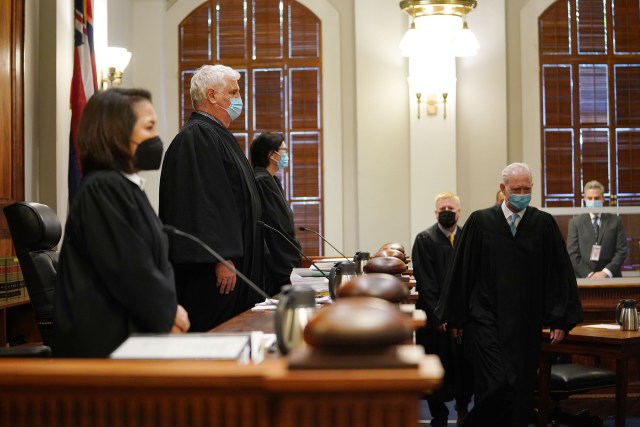 Hawaii State Supreme Court Chief Justice Mark Recktenwald flanked by associate justices enter court to hear oral arguments on a reapportionment case.