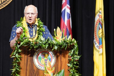 Mayor Rick Blangiardi speaks at podium located at the Mission Memorial Auditorium while reading speech from teleprompter.