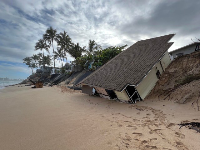 At Rocky Point on Oahu's North Shore a house sits on the beach after recently collapsing and sliding off the eroded sandy bluff where it was built, Tuesday, March 1, 2022. (Ronen Zilberman photo Civil Beat)