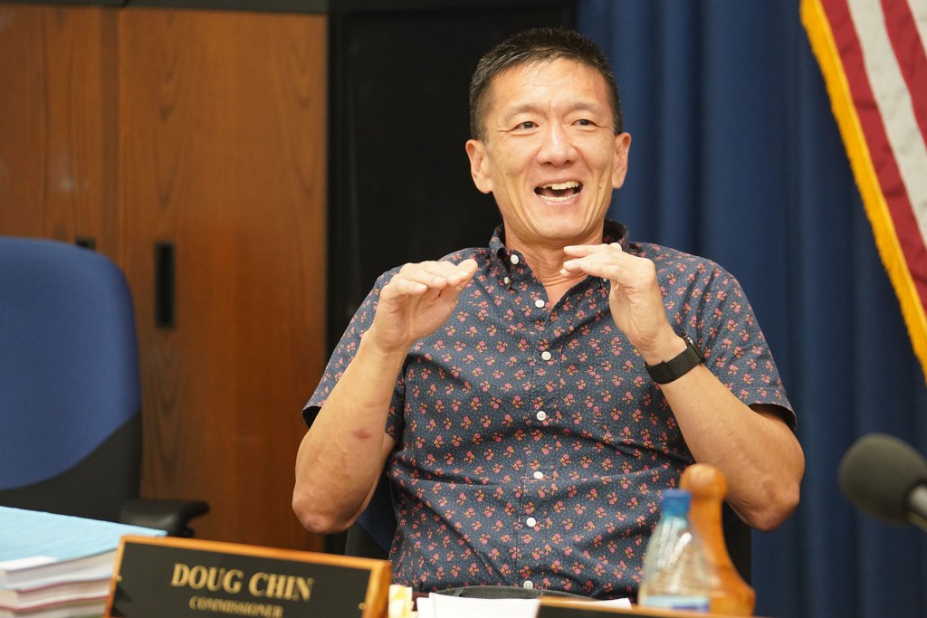 Honolulu Police Commission Commissioner Doug Chin gestures during meeting.