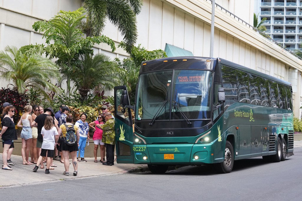 A Roberts Hawaii tour bus picks up passengers enroute to Pearl Harbor in Waikiki.