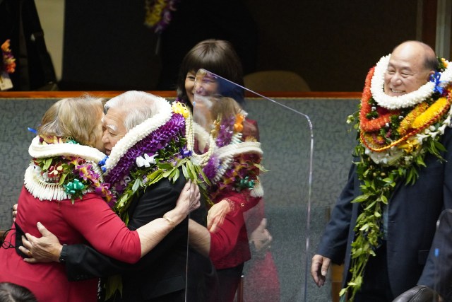 Left, Senators Rosalyn Baker hugs Senator Clarence Nishihara as Senator Brian Taniguchi looks on after floor session honoring the 3 that were retiring.