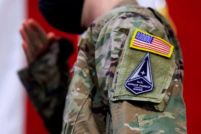 Air Force specialist salutes in a U.S. Space Force uniform during a ceremony for U.S. Air Force airmen transitioning to U.S. Space Force guardian designations Feb. 12, 2021, at Travis Air Force Base, Calif. About 1,000 Air National Guard troops who are assigned to space missions are mired in an identity crisis. According to commanders, the troops' units are torn between the Air Force, where they’ve historically been assigned, and the military’s shiny new Space Force, where they now work. (AP Photo/Noah Berger, File)