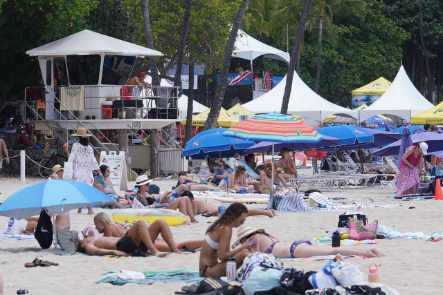 City and County Ocean Safety lifeguard tower amidst the many tents and beachgoers at Waikiki Beach.