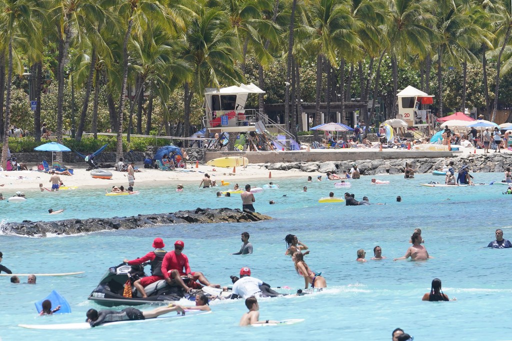 City and County Ocean Safety lifeguards ride a jet ski offshore Waikiki Beach.