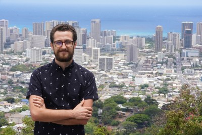 Trey Gordner stands with the backdrop of Honolulu in photograph made on Round Top.