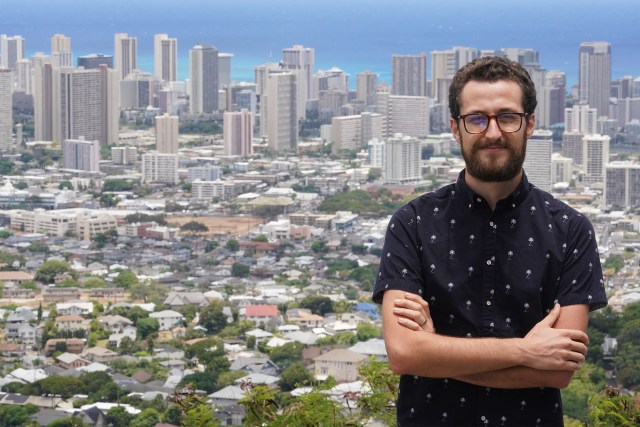 Trey Gordner stands with the backdrop of Honolulu in photograph made on Round Top.