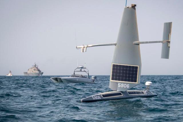 In this image provided by the U.S. Navy, a Saildrone Explorer, front to rear, a Devil Ray T-38 crewless vessel, a littoral combat ship, and a U.S. Coast Guard cutter sail in the Arabian Gulf, on June 26, 2022. The Navy is expediting development of drone ships aimed at expanding the reach of offensive firepower while keeping sailors on traditional warships farther from harm's way. (U.S. Navy photo by Chief Mass Communication Specialist Roland A. Franklin via AP)