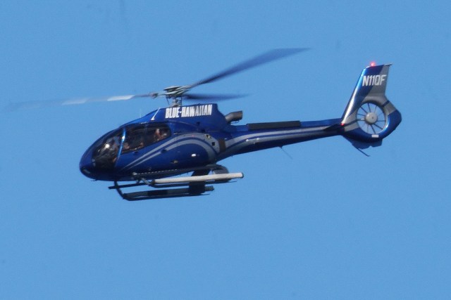 A Blue Hawaiian tour helicopter flies offshore Ala Moana Beach on way towards Waikiki.