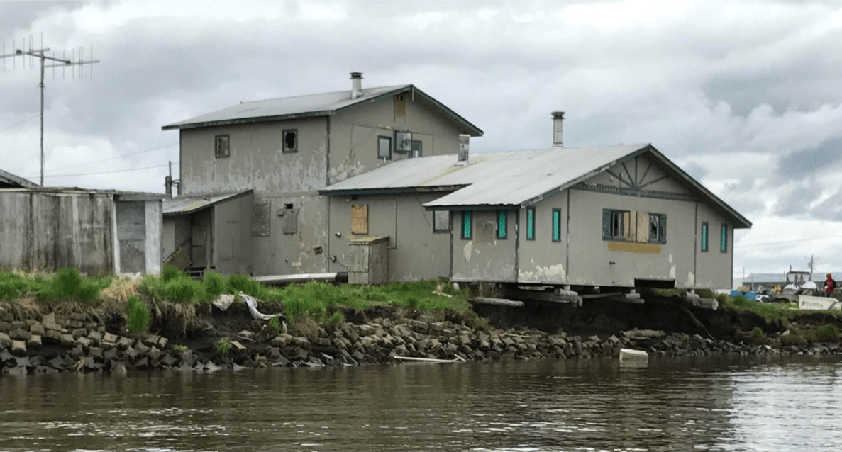 Homes on the riverbanks next to rising water