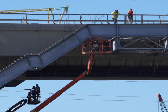 Workers stand on the HART Rail guideway construction near Middle Street.