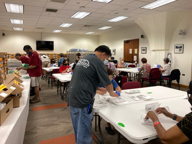 Elections volunteers separate ballots from envelopes