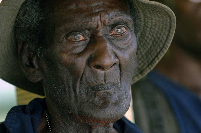 An elderly Solomon Islands Scout Eroni Kumana is pictured wearing a bucket hat.