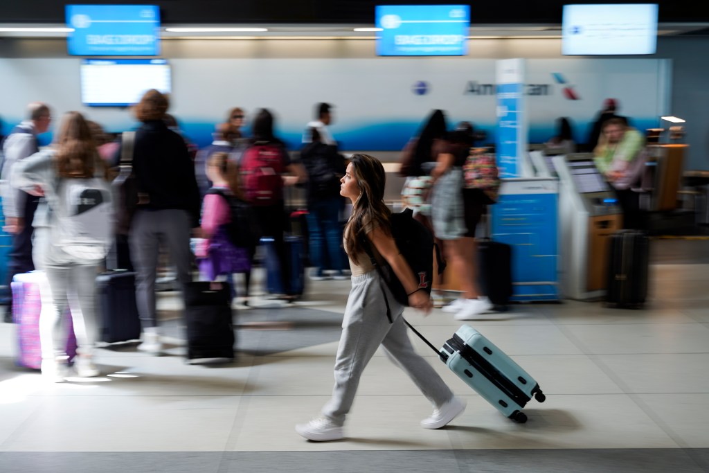 A person walks by the ticketing lobby at the Charlotte Douglas International Airport on Thursday, May 25, 2023, in Charlotte, N.C. Auto club AAA said this summer could be “one for the record books, especially at airports,” with more than 43 million Americans projected to travel 50 miles or more.   (AP Photo/Erik Verduzco)