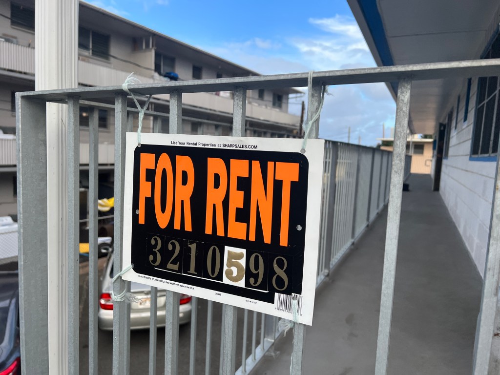 A "For Rent" sign posted outside of the Kapiolani Village Apartments.