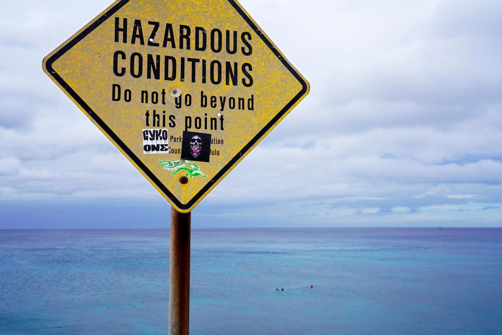 Electric Beach swimmers calm waters Leeward Oahu tropical storm hurricane Calvin Hawaii Hazardous conditions sign Pacific Ocean blue water