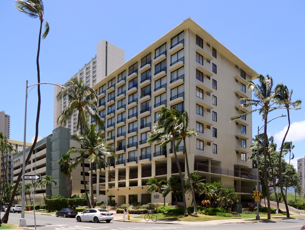 The apartment complex at 440 Seaside Avenue is the dominant feature in a scene from the corner of Aloha Drive and Seaside Avenue in Waikiki.