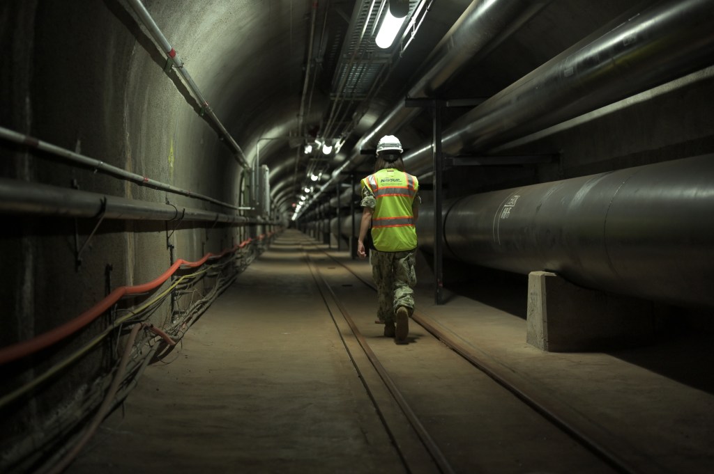 200717-N-TA290-1007 HONOLULU (July 17, 2020) Fuels director, LCDR Shannon Bencs walks a portion of the seven (7) miles of tunnels of the Red Hill Underground Fuel Storage Facility  (U.S. Navy photo by Daniel Mayberry/Released)