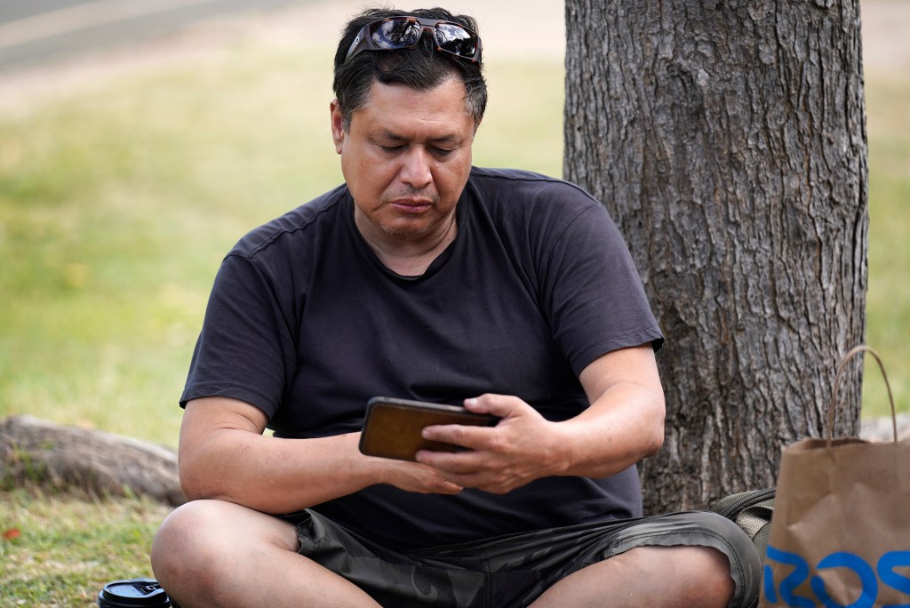 Alan Barrios, 53 of Lahaina, looks at videos of the fire Wednesday, Aug. 9, 2023, at an emergency shelter at Maui High School in Kahului. Barrios’ apartment was completely destroyed by a fire which consumed the town of Lahaina. (Kevin Fujii/Civil Beat/2023)