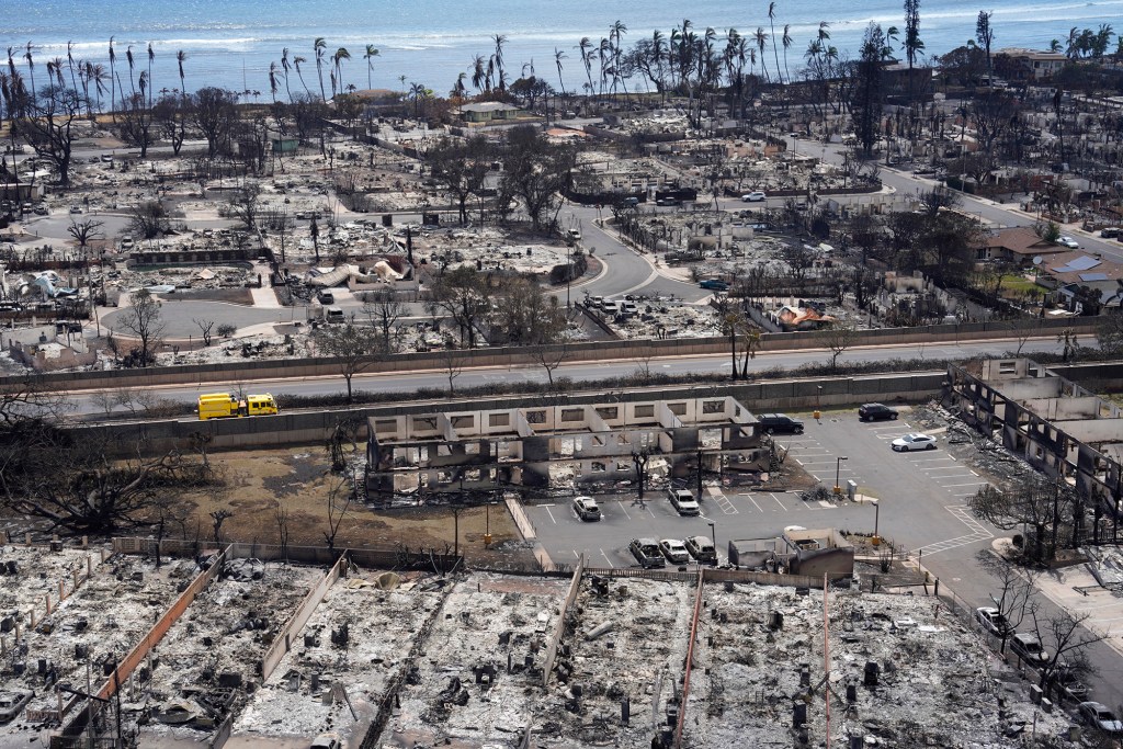 A fire engine drives past buildings destroyed by wildfire in the historic town of Lahania Thursday, Aug. 10, 2023, on Maui. (Kevin Fujii/Civil Beat/2023)