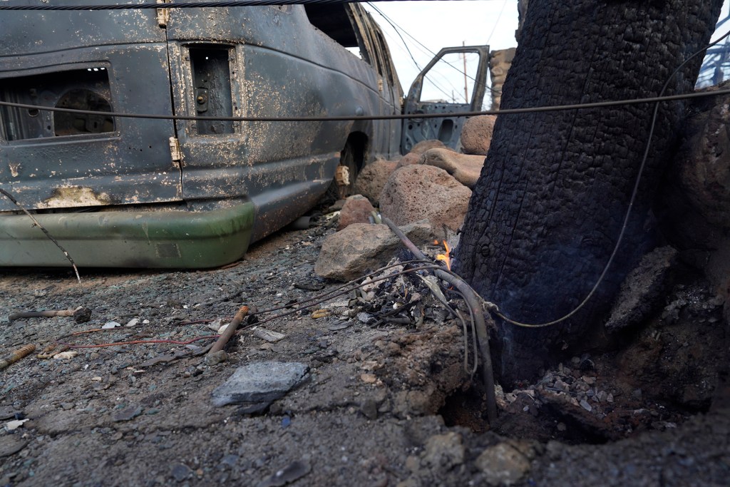 A fire under a utility pole remains ignited Thursday, Aug. 10, 2023, in Lahaina. (Kevin Fujii/Civil Beat/2023)
