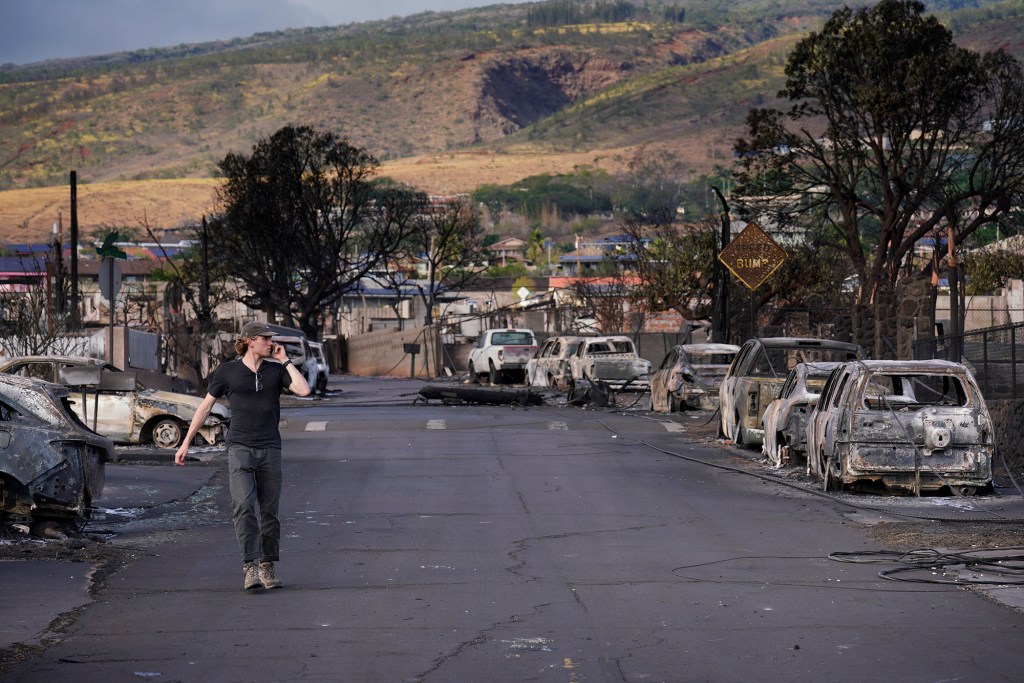 Honolulu Civil Beat reporter Jack Truesdale takes a phone call amid the destruction of Lahania town Thursday, Aug. 10, 2023, in Maui. Two days prior, a large, fast-moving wildfire consumed this historical West Maui town. (Kevin Fujii/Civil Beat/2023)