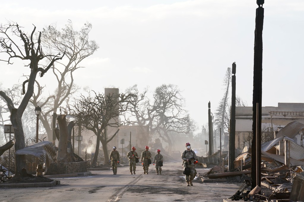 Hawaii National Guardsmen walk Front Street searching for people Thursday, Aug. 10, 2023, in Lahaina. They mark buildings and vehicles to indicate if people were located in an initial, no-entry search. (Kevin Fujii/Civil Beat/2023)