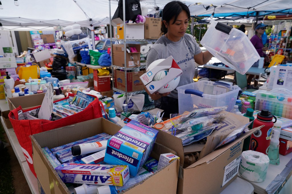 Supplies are gathered for those affected by the wildfires Sunday, Aug. 13, 2023, in Wahikuli neighborhood, north of Lahaina town and south of Kaanapali. A large fire consumed areas of West Maui last week. Utilities have not been fully restored.  (Kevin Fujii/Civil Beat/2023)