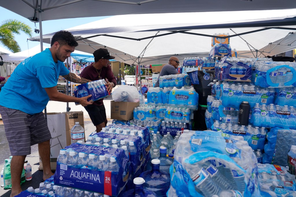 Wahikuli residents move bottled water Sunday, Aug. 13, 2023, north of Lahaina town and south of Kaanapali. A large fire consumed areas of West Maui last week. Utilities have not been fully restored. (Kevin Fujii/Civil Beat/2023)