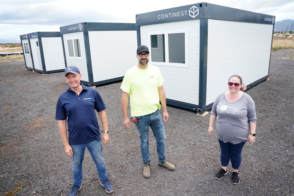 Continest CEO North America Yan Pronin, from left, Hawaii Off-Grid Architect & Engineering principal David Sellers and Family Life Center COO Dr. Ashley Kelly stand outside of  structures for emergency housing Monday, Aug. 21, 2023, in Kahului. The Biden are touring areas of Maui affected by wildfires. (Kevin Fujii/Civil Beat/2023)