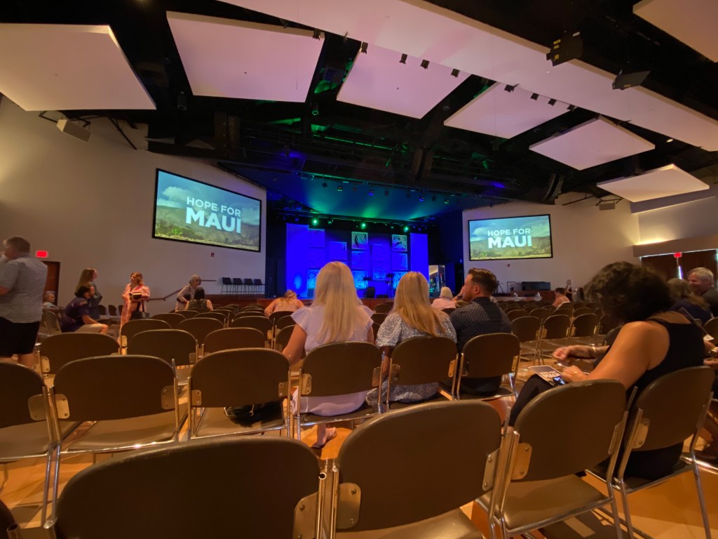 Large room inside a church as it starts to fill with people, taken from the back row