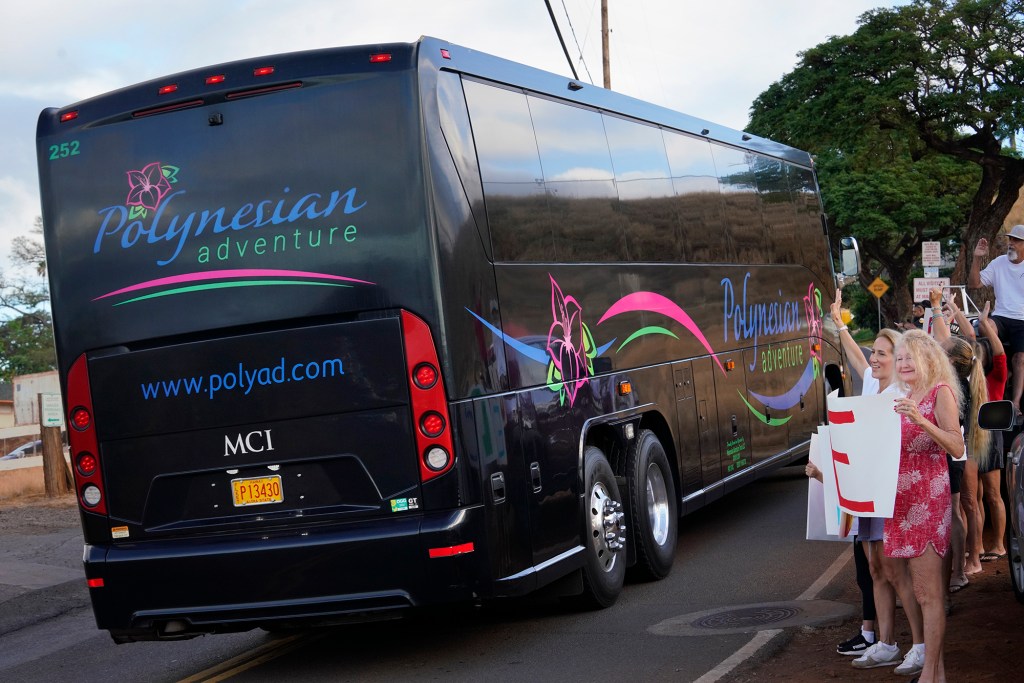 A tour bus carries students to Lahainaluna High School Monday, Oct. 16, 2023, in Lahaina. The sign on the front of the bus reads: Lahainaluna High School Central. The school has been closed since the Aug. 8 fire and studying at other schools in Maui. (Kevin Fujii/Civil Beat/2023)