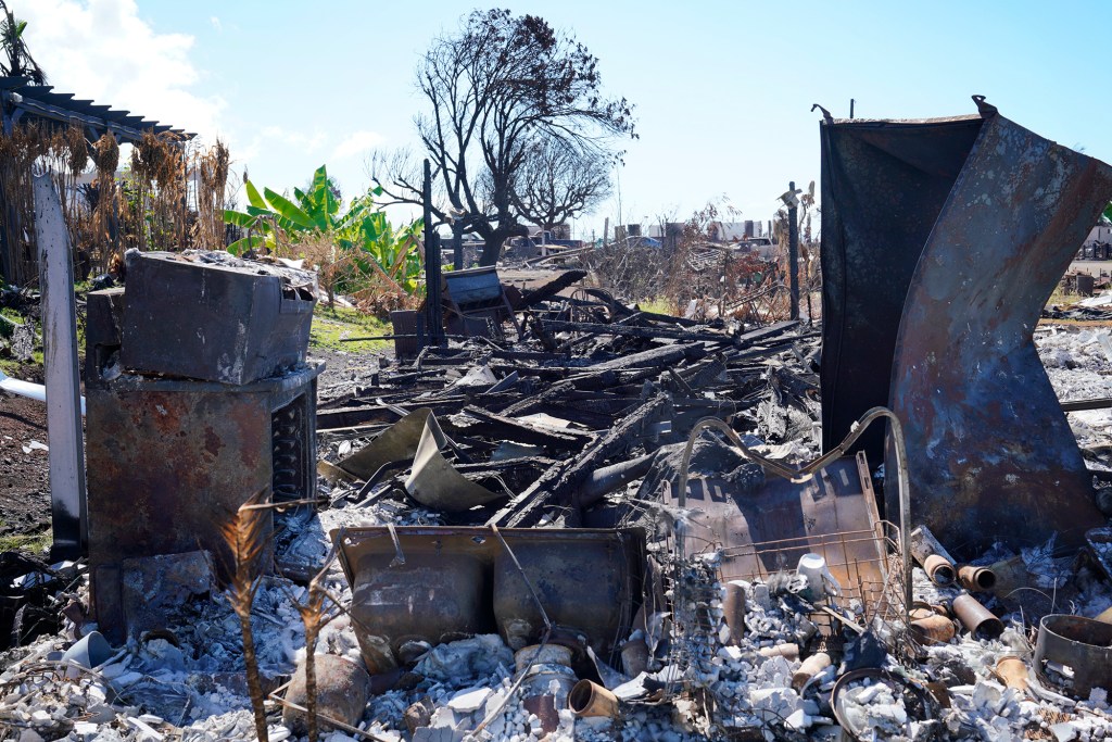A soil stabilizer was sprayed on burned ash and debris of this house Wednesday, Oct. 18, 2023, in Lahaina. While it is difficult to visually discern the area was sprayed, once dried, it will feel different. (Kevin Fujii/Civil Beat/2023)