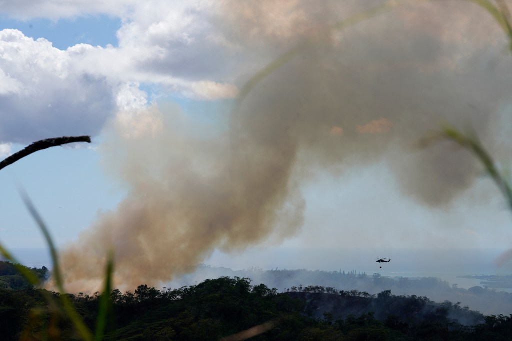 A military helicopter flies toward a large vegetation fire in the Mililani Mauka-Launani Valley area Monday, Oct. 30, 2023, as seen from the Ewa Forest Reserve. (Kevin Fujii/Civil Beat/2023)