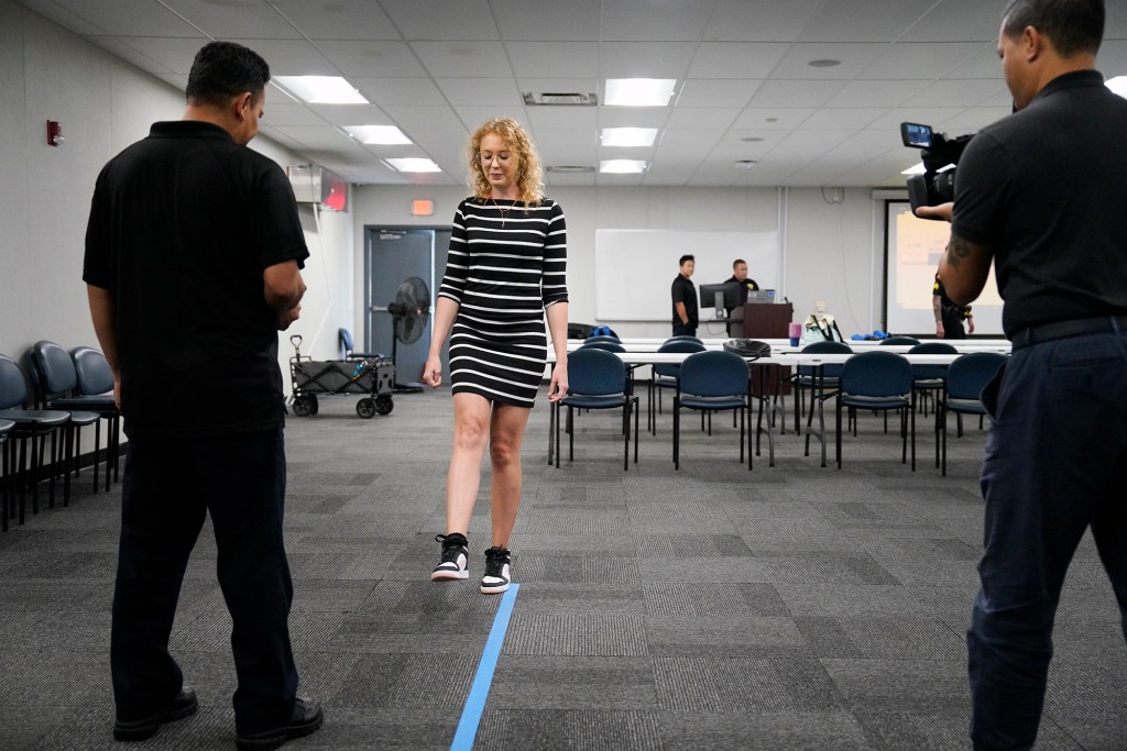 Civil Beat reporter Madeleine Valera stands on one foot during a Honolulu Police Department media workshop on Operating a Vehicle Under the Influence of an Intoxicant also known as OVUII or DUI on Saturday, Nov. 18, 2023, at the HPD training facility in Waipahu. Here Valera stands on one foot while counting. HPD’s message comes as the winter holidays approach. (Kevin Fujii/Civil Beat/2023)