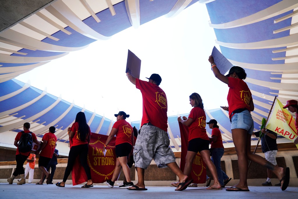 Under the iconic opening ceiling of the Hawaii State Capitol, Lahaina Strong community representatives deliver more than 10,000 signatures to Gov. Josh Green’s office Tuesday, Oct. 3, 2023, in Honolulu. Residents of Lahaina and Maui-wide are asking to keep tourism to West Maui closed until they’re ready. (Kevin Fujii/Civil Beat/2023)