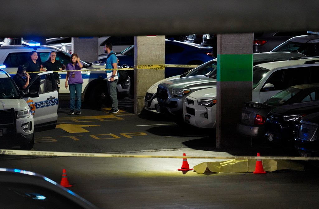 A body lies in a Pearlridge Center parking garage Friday, Dec. 22, 2023, in Honolulu. The deceased is reported to be Theresa Cachuela, 33. Pali Momi Medical Center and Bank of Hawaii Pearlridge were on lockdown. The shooter is currently at large. (Kevin Fujii/Civil Beat/2023)