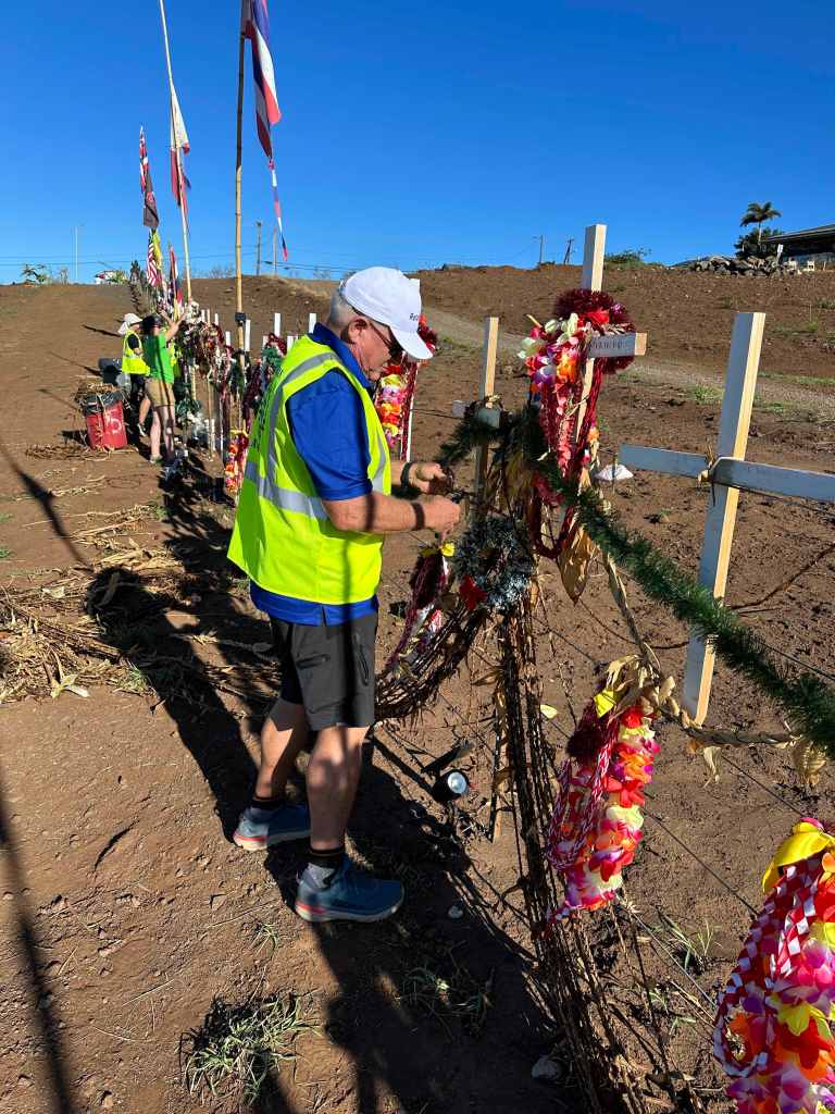 Lanny Brown of the Rotary Club of Lahaina Sunset participated in a cleanup Saturday, Dec. 9, 2023, at the roadside memorial honoring victims of the Aug. 8 wildfire. (Christie Wilson/Civil Beat/2023)