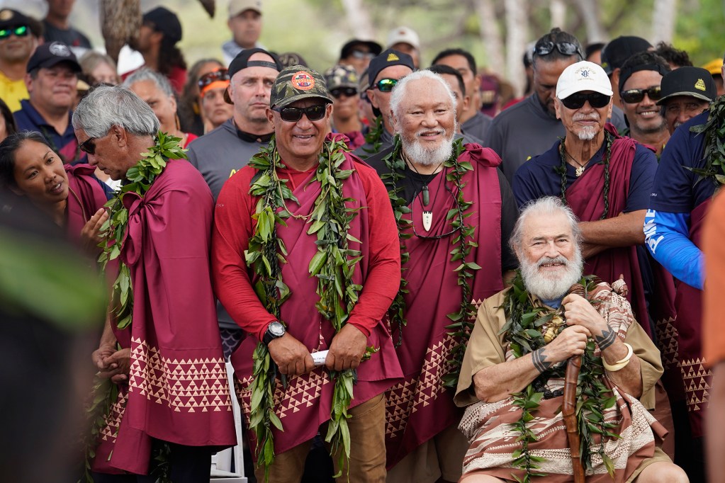 Hokule’a crew including Uncle Archie Kalepa, center wearing cap and sunglasses, enjoys a light moment after the Wa'a Kaulua Protocol for the voyaging canoe during the Hoʻūlu Lahaina Unity Walk Saturday, Jan. 20, 2024, in Lahaina. . (Kevin Fujii/Civil Beat/2024)